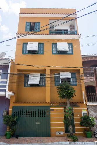 a yellow house with a green gate in front of it at CANTO DA ARVORE 1 in Arraial do Cabo