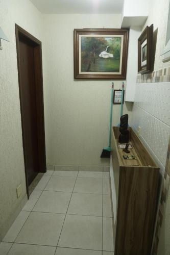 a bathroom with a counter and a painting on the wall at CANTO DA ARVORE 1 in Arraial do Cabo
