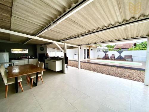 eine Küche und einen Essbereich mit einem großen Holztisch in der Unterkunft Casa Balneário Picarras in Piçarras