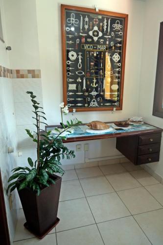 a desk in a room with a potted plant at CANTO DA ARVORE 1 in Arraial do Cabo