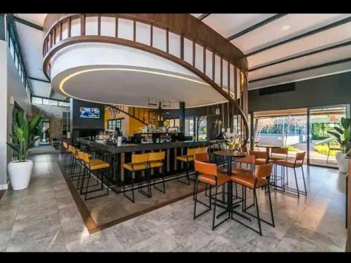 a dining room with a bar with yellow chairs at URlyfstyle Cottage @ Kikuyu waterfall in Midrand