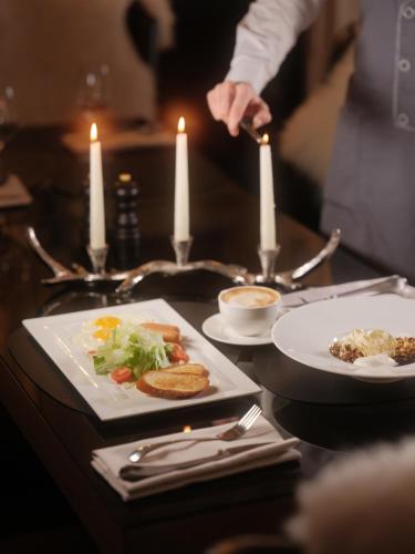 a table with plates of food on a table with candles at Villa Buko in Bukovel