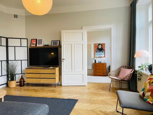 a living room with a tv and a door at Cool and light 2 room apartment in SoFo in Stockholm