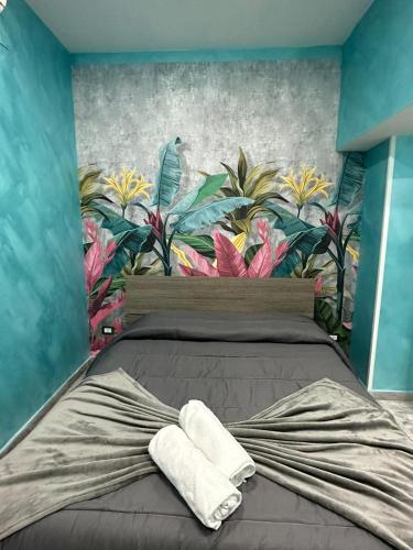 een slaapkamer met een bed met een muurschildering van bloemen aan de muur bij C.D.M in Napels