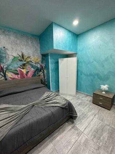 een slaapkamer met een bed en een blauwe muur bij C.D.M in Napels