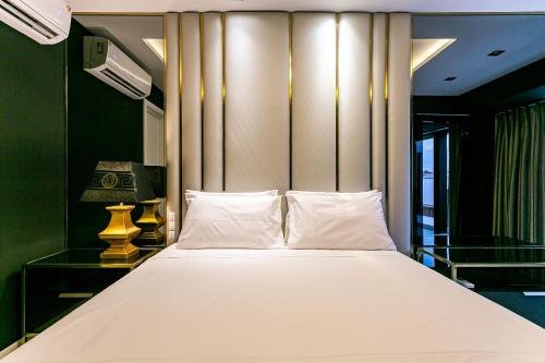 um quarto com uma cama branca e uma parede em Apto duplex lindo e moderno com jacuzzi JRR410 em Florianópolis