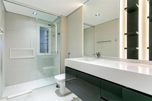 uma casa de banho com um lavatório, um WC e um espelho. em Apto duplex lindo e moderno com jacuzzi JRR410 em Florianópolis