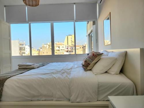 sypialnia z dużym łóżkiem i dużym oknem w obiekcie Sunny Eclectic 3BR house in Gemmayze w Bejrucie