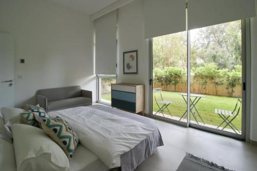 a bedroom with a bed and a large window at Amchit Bay Beach Residences 2BR w Private Pool in Jbeil