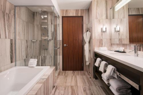 a bathroom with a tub and two sinks and a shower at The Westin Cleveland Downtown in Cleveland