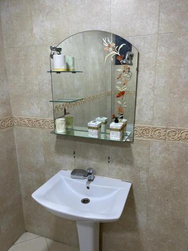 lavabo blanco en el baño con espejo en Kenitra great location, en Kenitra