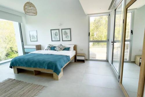 - une chambre avec un grand lit et de grandes fenêtres dans l'établissement Amchit Bay Beach Residences 3BR w Indoor Jacuzzi, à Byblos