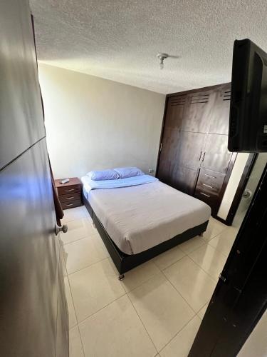 1 dormitorio con 1 cama y TV de pantalla plana en Mirador Inn, en Pasto