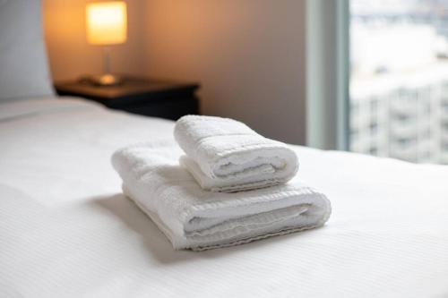 drie handdoeken gestapeld op een bed in een hotelkamer bij Toronto Condo with a View, St. Lawrence Market in Toronto