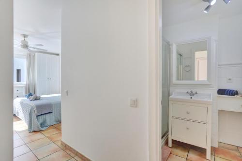 Baño blanco con lavabo y espejo en SunsetView apartment El Cotillo 2-4 personas, en Cotillo