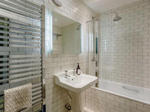 een witte badkamer met een wastafel en een bad bij 1 bed property in York 87323 in Green Hammerton