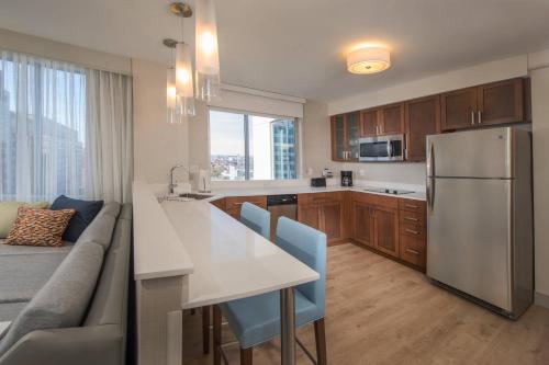 a kitchen with a refrigerator and a table and a couch at Residence Inn by Marriott Baltimore at The Johns Hopkins Medical Campus in Baltimore
