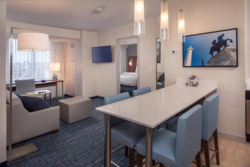 a hotel room with a table and chairs and a living room at Residence Inn by Marriott Baltimore at The Johns Hopkins Medical Campus in Baltimore