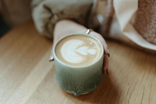 a person holding a cup of coffee on a table at Residence Inn by Marriott Portland Downtown/Pearl District in Portland