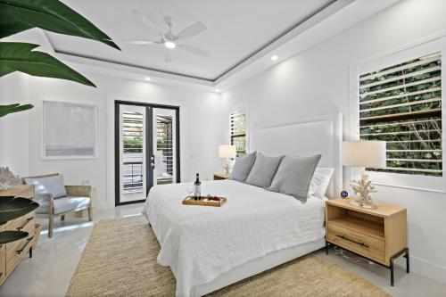 a white bedroom with a large bed and a desk at Pet-friendly home near shops with pool and spa in Marco Island