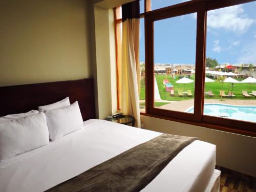 a bedroom with a bed with a view of a pool at Hotel Resort Thiago in Chincha Alta