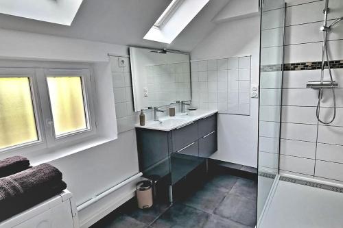 a white bathroom with a sink and a shower at Le Gite de MuMu in Vaudes