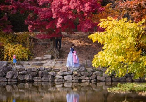 a woman in a dress standing on rocks near a body of water at Stay Vibe Healing House in Seoul