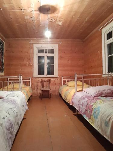 Shuakhevi的住宿－Guest House Dedeshvilebi，带三张床和窗户的客房