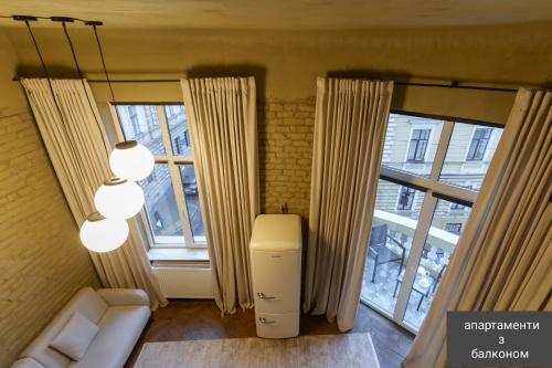 uma sala de estar com duas janelas grandes e um aquecedor em Apart hotel на Франка em Chernivtsi