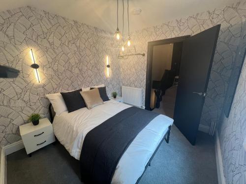 1 dormitorio con 1 cama con manta blanca y negra en Lancaster Place 18, en Carnforth