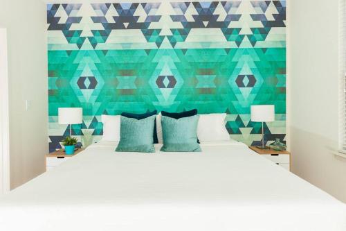 a bedroom with a white bed with blue pillows at League Flats Uptown at West Trade Street in Charlotte