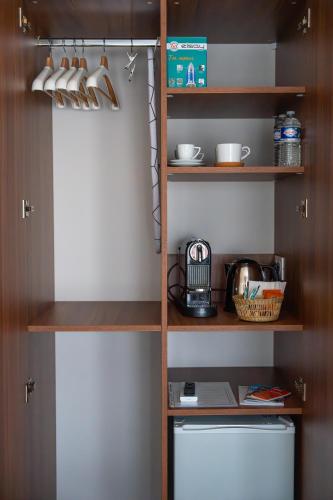 a kitchen with a pantry with a shelf above a toilet at LE NID, superbe chambre d'hôtes in Mauves-sur-Loire