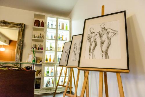 two drawings of men on easels in a room at Monte Do Malhao - Art, Eco & Spa in Castro Marim