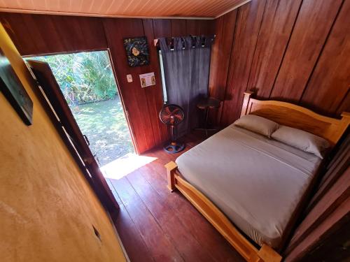 een kleine slaapkamer met een bed en een raam bij Hostel Yinary in Drake
