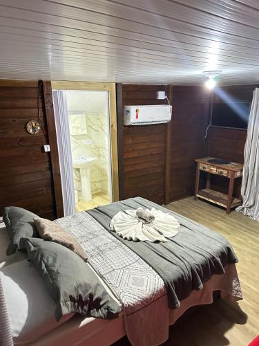 a bed in a small room with a table at Pousada & Camping Tubarão in Ilha do Mel