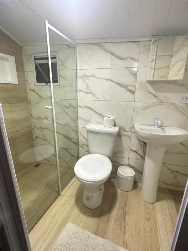 a bathroom with a toilet and a sink at Pousada & Camping Tubarão in Ilha do Mel