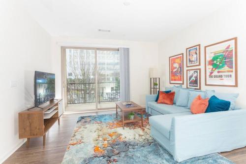 a living room with a blue couch and a tv at League Flats Uptown at West Trade Street in Charlotte