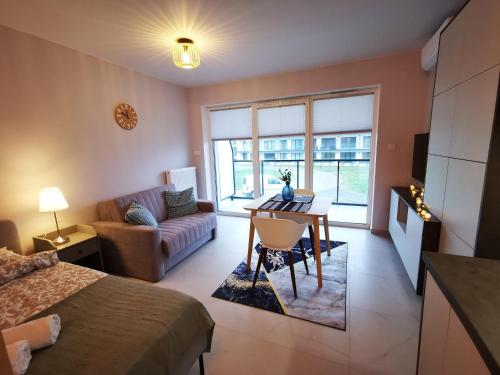 a room with a bed and a table and a couch at Apolonia apartament II- SPA in Dziwnów