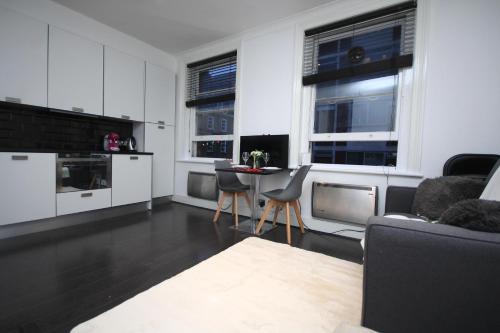 a living room with white cabinets and a table and chairs at Chic Flat in Oxford Circus in London