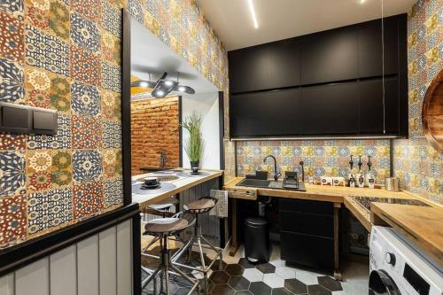 a kitchen with colorful tiles on the wall at Friday’s apartman in Debrecen