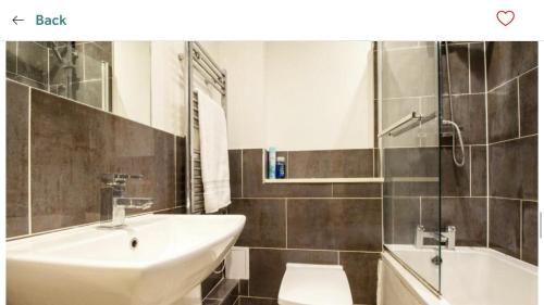 a bathroom with a sink and a toilet and a tub at Captivating 1-Bed Apartment in Southampton in Southampton