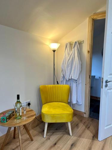 a yellow chair and a table in a room at Speir dorcha cabin in Omagh