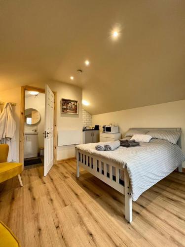 a bedroom with a large bed and a kitchen at Speir dorcha cabin in Omagh