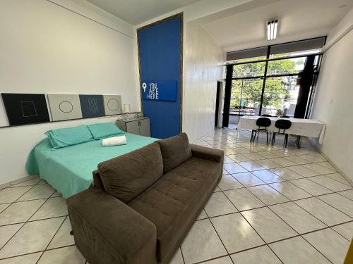 a living room with a bed and a couch at Apartamento no Centro São João da Boa Vista in São João da Boa Vista