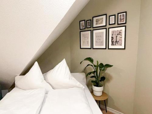 a bedroom with a white bed and a potted plant at NAMI - ROBIN - Helle Apartments mitten in der Stadt in Memmingen