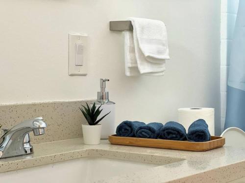 een badkamer met een wastafel en een dienblad met handdoeken bij Trendy 2BR Near Hollywood Hotspots - BR9 in Los Angeles