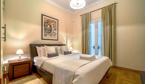 Un dormitorio con una cama grande y una ventana en Kolonaki, Marasli en Athens