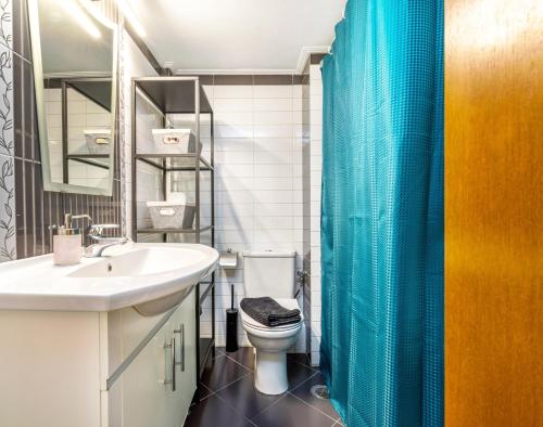 baño con aseo y cortina de ducha azul en Kolonaki, Marasli en Athens