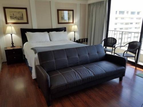 ホノルルにあるBrooks Beach Vacations Wyndham 4 Star Resort 1805 Waikikiのベッドルーム(ベッド1台、ソファ付)
