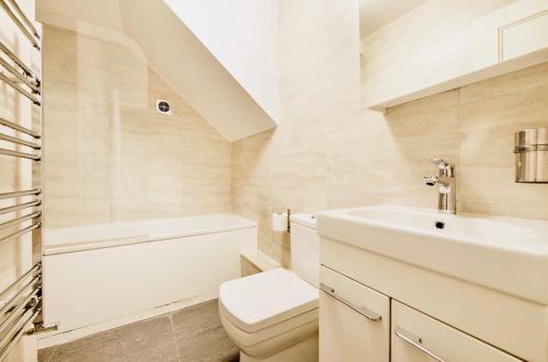 a bathroom with a sink and a toilet and a tub at Spacious & Charming garden flat -Zone 2- Great for Central London access in London